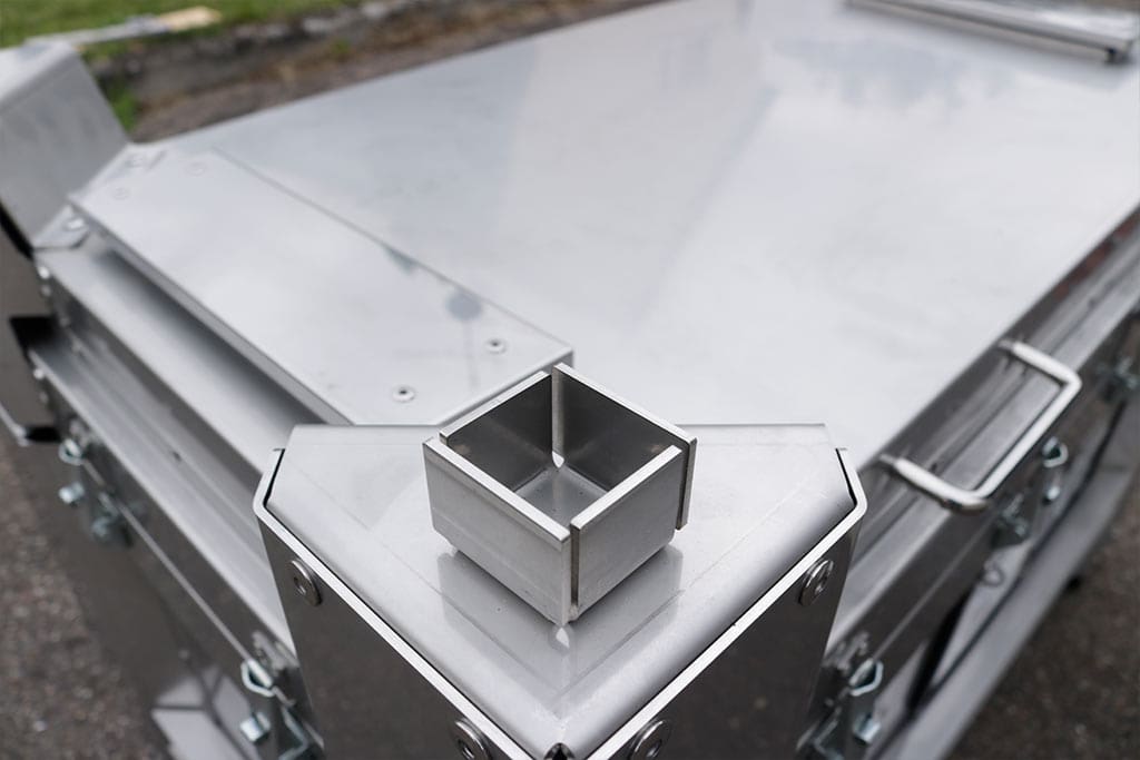 Industriell metallboks med sølvfarget overflate, kantet form og detaljrik utforming.